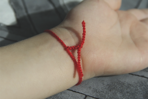 How to wear a red thread on your wrist